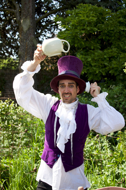 Sam John as the Hatter taking an urgent call